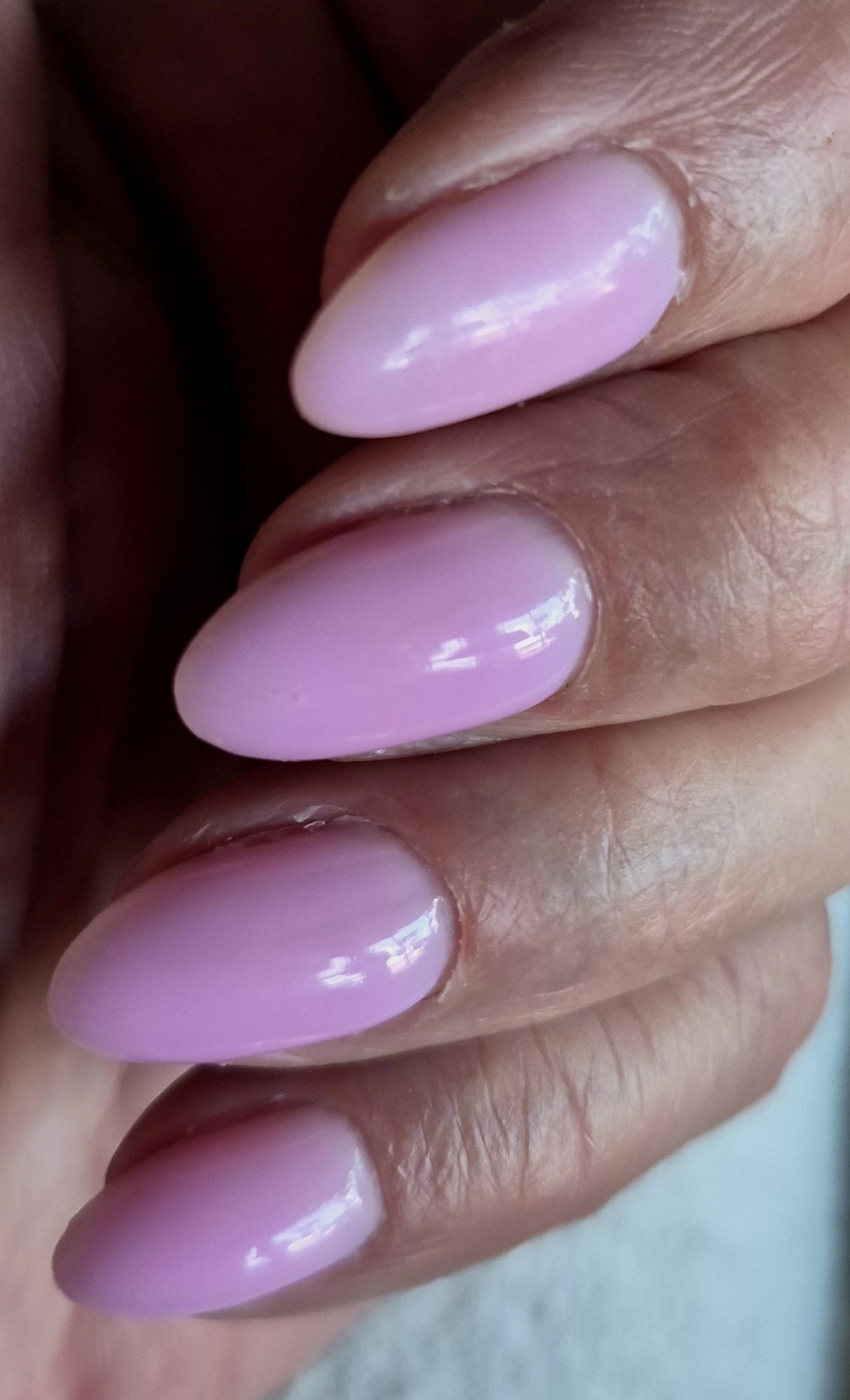 Glanzend roze amandelvormige nagels, close-up
