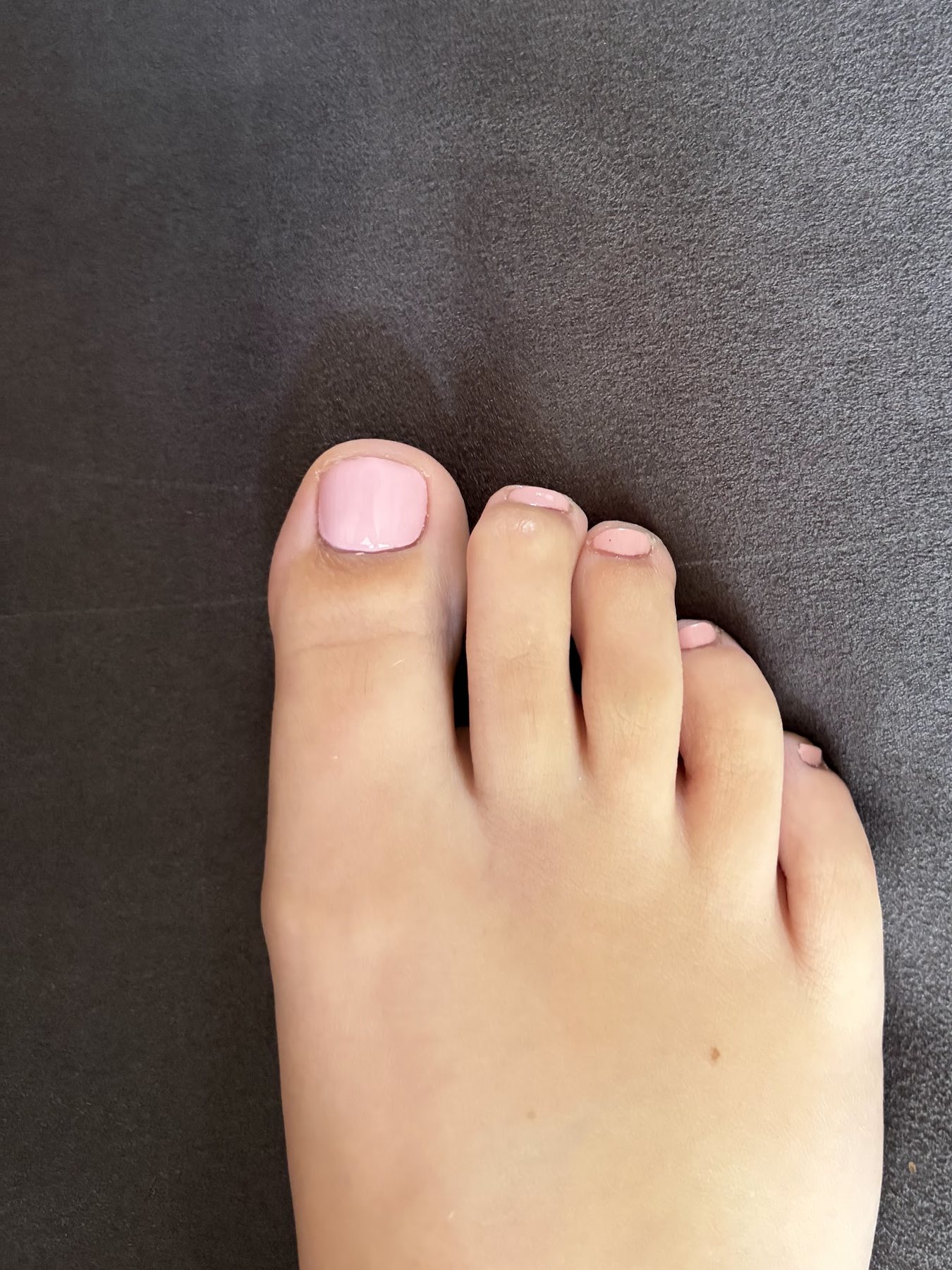 Roze gelakte teennagels na een pedicure